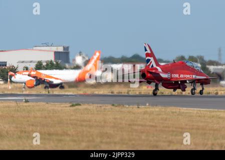 Aeroporto Southend di Londra, Essex, Regno Unito. 19th ago, 2022. Le frecce rosse della RAF stanno utilizzando l’aeroporto civile per operare da per gli spettacoli aerei di questo fine settimana a Eastbourne e Folkestone. Le frecce rosse sono arrivate questa sera, arrivando nella loro famosa formazione di frecce prima di rompersi a terra. EasyJet partenza per Faro tenendo come Red Arrow jet taxi fuori pista Foto Stock