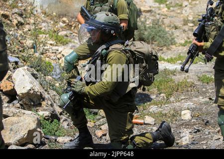 Nablus, Palestina. 19th ago, 2022. Un soldato israeliano prende la copertura, durante la manifestazione contro gli insediamenti israeliani nel villaggio di Kafr Gheddaum, vicino alla città di Nablus, in Cisgiordania. (Foto di Nasser Ishtayeh/SOPA Images/Sipa USA) Credit: Sipa USA/Alamy Live News Foto Stock