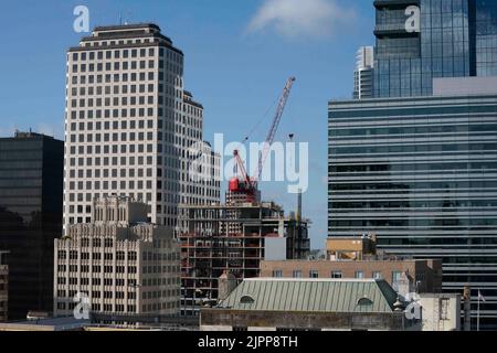 Austin Texas USA, agosto 2 2022: Una gru luffing si trova in cima allo scheletro di un hotel a 28 piani presto in via di costruzione, racchiuso tra due altri edifici alti del centro città. Ci sono almeno due dozzine di edifici in costruzione nel centro della città con molti altri sulla tavola da disegno. ©Bob Daemmrich Foto Stock