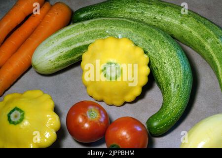 Una varietà di verdure fresche, direttamente da un giardino di casa, tra cui cetrioli, carote e zucca. Foto Stock