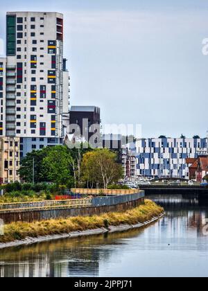 Uno scatto verticale degli edifici dell'Università di Suffolk e del mulino di Cranfield vicino ad un fiume in Ipswich, Regno Unito Foto Stock