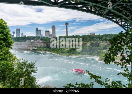Cascate del Niagara, NY - 31 luglio 2022: Skyline delle Cascate del Niagara, Ontario, Canada, con il tour in barca Hornblower Niagara sul fiume sottostante, incorniciato dalla Foto Stock