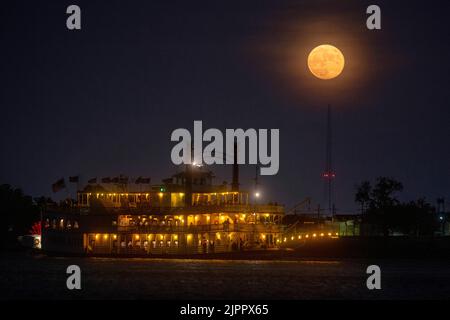 New Orleans, Louisiana, Stati Uniti. 22nd ago, 2021. Un piroscafo fa la sua strada sul fiume Mississippi mentre la luna sorge su New Orleans la domenica sera, 22 agosto 2021. La Luna di Sturgeon di Agosto, che era anche una rara Luna Blu, era piena alle 7:02 DI MATTINA ora locale Domenica, ma la luna ancora messo su uno spettacolo quando è aumentato su New Orleans più tardi quella sera. New Orleans ospita la sede della NASA Michoud Assembly, dove è in costruzione la fase centrale del sistema di lancio spaziale che farà tornare le persone sulla luna. Credit: Michael DeMocker/NASA/ZUMA Wire/Alamy Live News Foto Stock