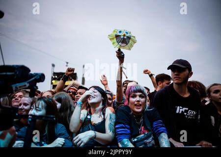 19 agosto 2022, Sassonia, Großpösna: I visitatori festeggiano di fronte al palco all'inizio del festival Highfield. Dal punto di vista degli organizzatori, il Festival degli Highfield presso il lago Störmthal, vicino a Lipsia, ha avuto un buon inizio. Circa 35.000 biglietti per l'evento musicale di tre giorni sono stati venduti in anticipo. Foto: Alexander Prautzsch/dpa-Zentralbild/dpa Foto Stock