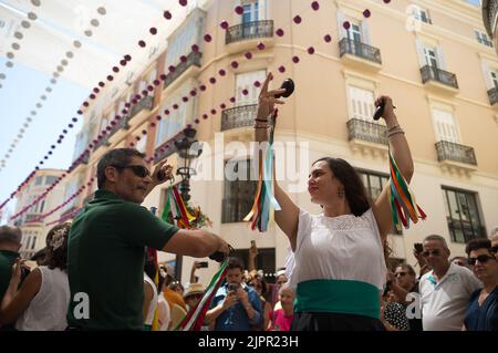 Un gruppo di persone si vede ballare 'Verdiales' (stile flamenco andaluso) in via Marques de Larios, mentre prendono parte alla fiera di Malaga 2022. Dopo due anni di cancellazione a causa della pandemia di coronavirus, migliaia di persone si riuniscono nelle strade principali della città per partecipare alla Fiera di Malaga in un'atmosfera festosa. Tra una settimana, migliaia di turisti e abitanti del luogo potranno assistere a concerti, balli di flamenco per le strade e altre attività come la fiera della corrida o gli spettacoli di cavalli. Foto Stock