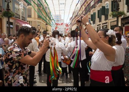 Un gruppo di persone è visto ballare 'Verdiales' (stile flamenco andaluso) in via Marques de Larios, mentre prendono parte alla fiera di Malaga 2022. Dopo due anni di cancellazione a causa della pandemia di coronavirus, migliaia di persone si riuniscono nelle strade principali della città per partecipare alla Fiera di Malaga in un'atmosfera festosa. Tra una settimana, migliaia di turisti e abitanti del luogo potranno assistere a concerti, balli di flamenco per le strade e altre attività come la fiera della corrida o gli spettacoli di cavalli. Foto Stock