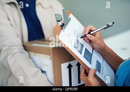 Consegna puntualmente, sempre. Primo piano di una donna che firma per una consegna dal corriere. Foto Stock