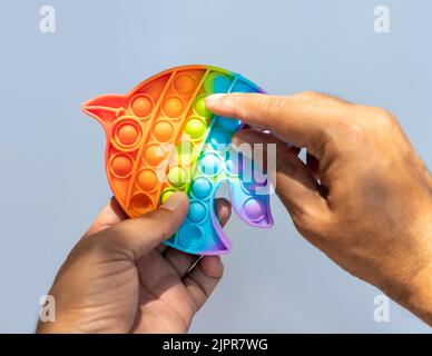 Tenere in mano e giocare anti stress pop gioco giocattolo Foto Stock