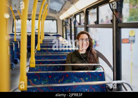 Questo autobus mi porta ovunque. Ritratto ad angolo alto di una giovane donna attraente che ascolta musica mentre si siede su un autobus. Foto Stock
