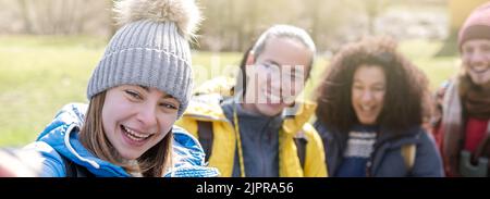 Gorup di amici felici escursionisti con zaini che prendono selfie ritratto in campagna - sorridendo turisti arrampicata felice godendo le vacanze in montagna Foto Stock