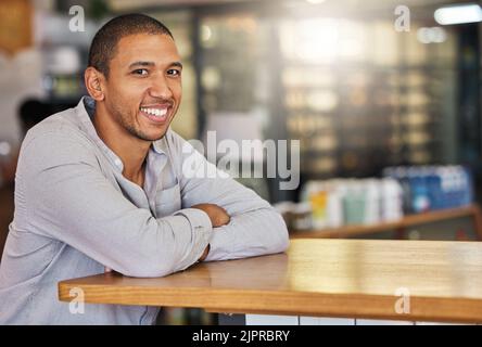 Entrepreneur or small business owner of cafe or coffee shop at counter happy and smiling. Young, confident and successful boss, manager or leader of a Foto Stock