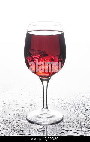 Bicchiere di vino con cristalli di ghiaccio su un sfondo di vetro Foto Stock