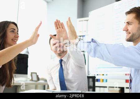 Un team di dipendenti molto gioiosi offre cinque successi per festeggiare Foto Stock