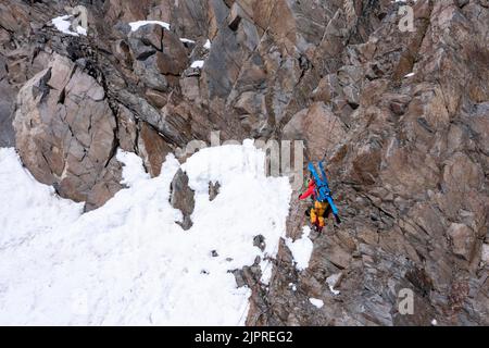 Tour in alta quota, gli sciatori si abbassano su una scogliera, Stubai, Tirolo, Austria Foto Stock