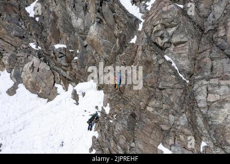 Tour in alta quota, gli sciatori si abbassano su una scogliera, Stubai, Tirolo, Austria Foto Stock