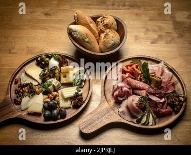 piatto misto europeo di salumi e formaggi affettati su tavola di legno Foto Stock