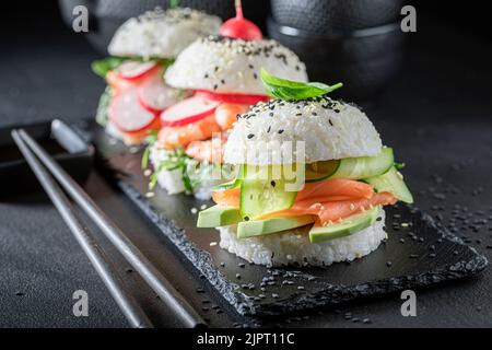 Hamburger di sushi delizioso e squisito con verdure e pesce come antipasti giapponesi. Sushi con pesce preparato in modo unico. Foto Stock