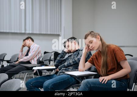 Una pausa tra le classi della scuola superiore. Gli studenti si riposano e dormono in classe a causa del gran numero di lezioni e del lavoro eccessivo. Foto Stock