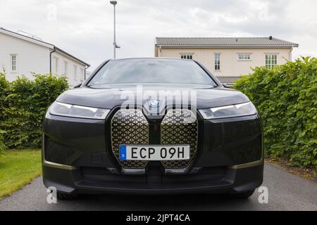 Vista ravvicinata della nuova auto elettrica BMW IX40 nel parcheggio privato della villa nelle nuvolose giornate estive. Svezia. Foto Stock