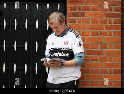 Craven Cottage, Londra, Regno Unito. 20th ago, 2022. Premier League Football, Fulham contro Brentford; Fulham fan all'esterno di Craven Cottage Reading programma di incontro ufficiale di oggi con Andreas Pereira di Fulham in prima pagina Credit: Action Plus Sports/Alamy Live News Foto Stock