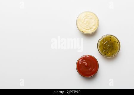 Diversi tipi di salse in ciotole su un pannello colorato . Vista dall'alto, vari salse copia spazio. Foto Stock