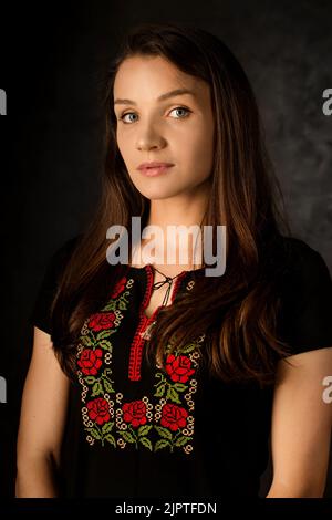 Ritratto di una donna Ucraina in costume popolare nazionale su sfondo scuro Foto Stock