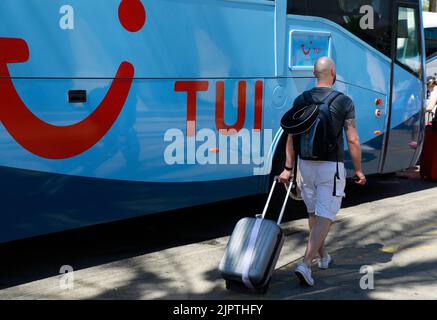 Palma, Spagna. 20th ago, 2022. Un uomo cammina verso un autobus TUI sul terreno dell'aeroporto di Palma de Mallorca. Credit: Clara Margais/dpa/Alamy Live News Foto Stock