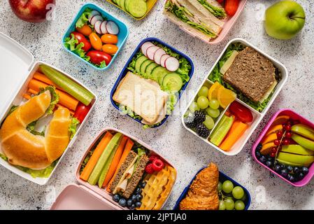 Shot di lunchboxes scuola con vari pasti nutrienti sani su sfondo di pietra Foto Stock