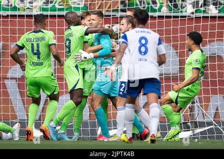 Wolfsburg, Germania. 20th ago, 2022. Calcio: Bundesliga, VfL Wolfsburg - FC Schalke 04, Giornata 3, Volkswagen Arena. Josuha Guilavogui di Wolfsburg abbraccia il portiere di Wolfsburg Koen Casteels (M) dopo un calcio di punizione. Credit: Swen Pförtner/dpa - NOTA IMPORTANTE: In conformità ai requisiti della DFL Deutsche Fußball Liga e del DFB Deutscher Fußball-Bund, è vietato utilizzare o utilizzare fotografie scattate nello stadio e/o della partita sotto forma di sequenze di immagini e/o serie di foto simili a video./dpa/Alamy Live News Foto Stock