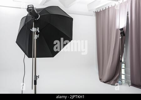 interno di luminoso spazio di studio fotografico con grande cicorama bianco con apparecchiature di illuminazione Foto Stock