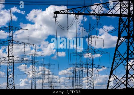 Molti poli elettrici di fronte al cielo con le nuvole Foto Stock