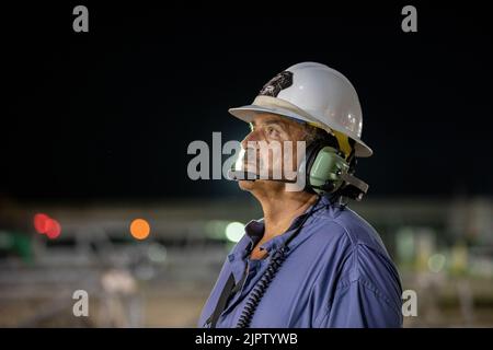 John Nesworthy, Jacobs Engineering, tecnico meccanico dei sistemi di trasporto cingolato/lanciatore mobile, guarda come il razzo del sistema di lancio spaziale della NASA con la navicella spaziale Orion lentamente rotola fuori dal Vehicle Assembly Building High Bay 3 in cima, al Kennedy Space Center, 16 agosto 2022, a Cape Canaveral, Florida. L'implementazione è in preparazione per il test di volo senza equipaggio previsto non prima dell'agosto 29. Credito: Ben Smegelsky/USA Navy Photo/Alamy Live News Foto Stock