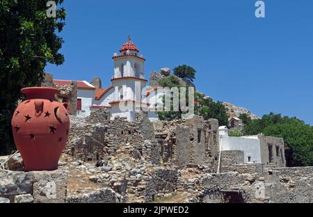 Chiesa di Agia Zoni, villaggio abbandonato di Mikro Horio, Tilos, isole Dodecanesi, Egeo meridionale, Grecia; con graziosa urna di terracotta in primo piano. May2022 Foto Stock