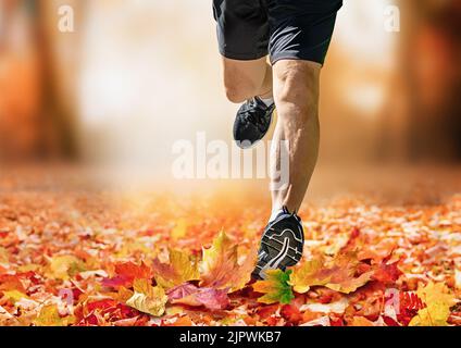 Uomo che corre nel parco autunnale verso la macchina fotografica Foto Stock