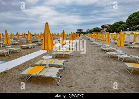Spiaggia vuota sulla costa adriatica. Ombrelloni chiusi lettini vuoti. Fine stagione turistica Foto Stock