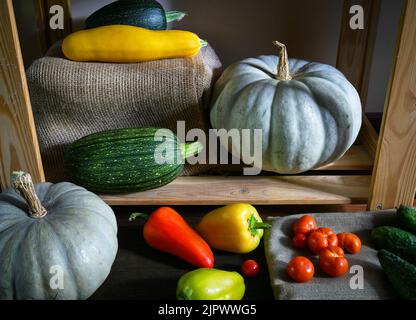 Zucche, midollo vegetale e pepe dolce in cucina, annata vita morta di cibo biologico. Foto di zucchine e pomodori in interni rustici. Concetto Foto Stock