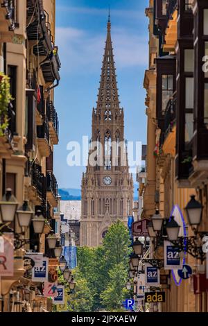 San Sebastian, Spagna - 25 giugno 2021: Vista lungo una strada nella città vecchia su buon Pastore della cattedrale di San Sebastian in rinascita gotica con 75 m di guglia Foto Stock
