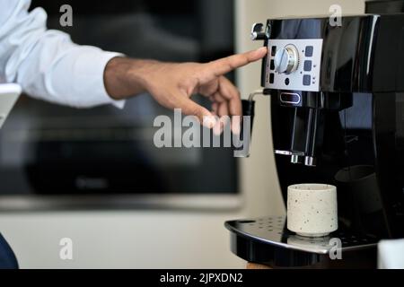 Maschio fare il caffè a mano in macchina in caffè o ufficio. Primo piano Foto Stock