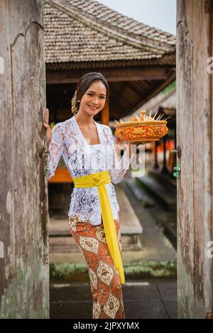 bella donna balinese che indossa abiti tradizionali nel villaggio Foto Stock