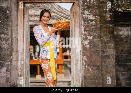 bella donna balinese che indossa abiti tradizionali nel villaggio Foto Stock