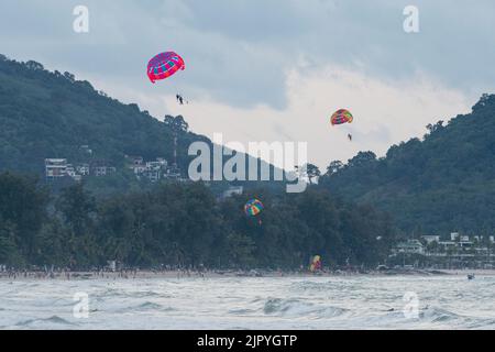 Parapendio sulla famosa spiaggia di Patong i turisti possono praticare attività in spiaggia durante le vacanze e fare parasailing, nuotare e guidare con moto d'acqua Foto Stock