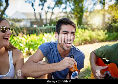 Lasciate che i bei momenti rotolino. Un giovane gruppo di amici che gustano qualche drink al di fuori del sole estivo. Foto Stock