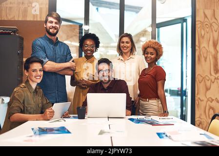È un ufficio pieno di menti creative. Ritratto di un gruppo eterogeneo di uomini d'affari che lavorano insieme in un ufficio. Foto Stock