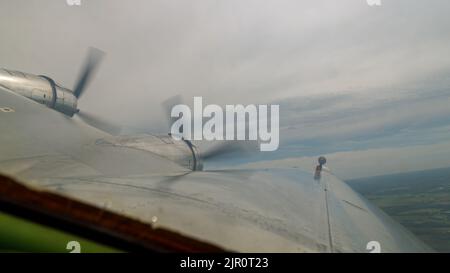 L'ala dell'aeroplano con due eliche durante il volo. Foto Stock