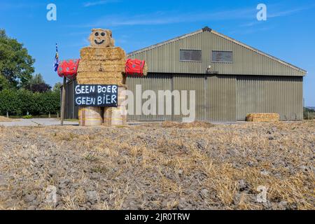 Gli agricoltori protestano contro leggi ambientali più severe sulle emissioni di C02 e azoto. Una bambola di paglia con testo No Farmer No Beer Foto Stock