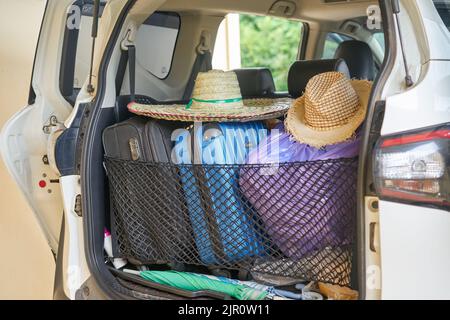 Un'auto pronta per il viaggio, con cappelli da sole e valigie. Foto Stock