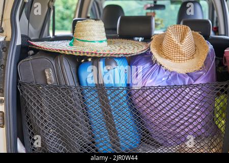 Un'auto pronta per il viaggio, con cappelli da sole e valigie. Foto Stock