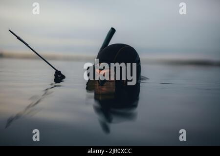 Subacqueo di pesca di spearfishing che tiene il suo fucile mentre sommerso in acqua di mare. Pescatori a caccia di pesci nel mezzo dell'oceano. Foto Stock