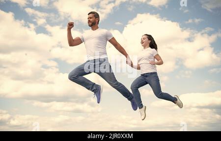 padre e figlia energici saltano nel cielo Foto Stock