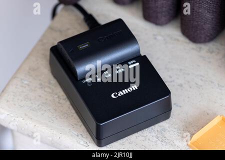 Brecht, Belgio - Agosto 5 2022: Ritratto di un caricabatterie per fotocamera canon che carica una batteria con l'indicatore spento. L'alimentazione è necessaria Foto Stock